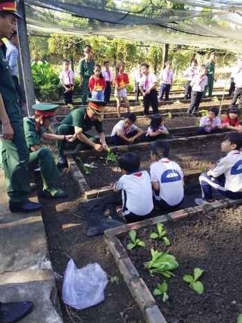 các em học sinh vô cùng thích thú khi nghe các chú bộ đội hướng dẫn cách trồng cây