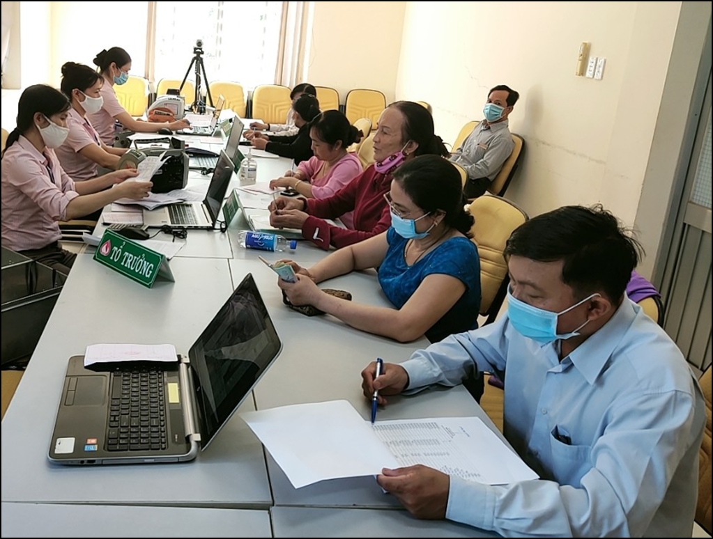 Hình ảnh: Cán bộ Ngân hàng CSXH huyện Đồng Phú thực hiện giao dịch với khách hàng vay vốn